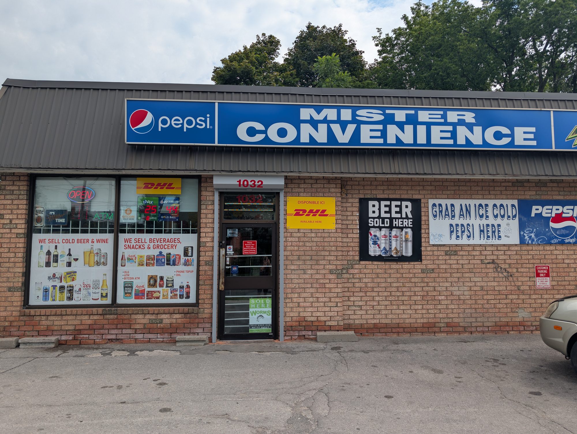 Brick convenience store exterior with a security shutter closed over the entrance door