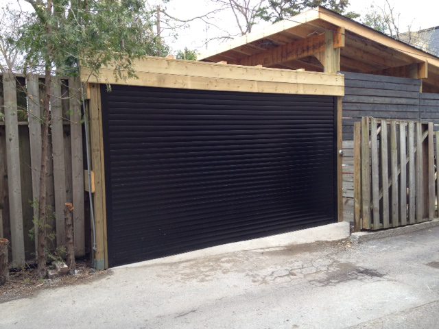 Narrow laneway garage with a roll-up shutter on a wood structure