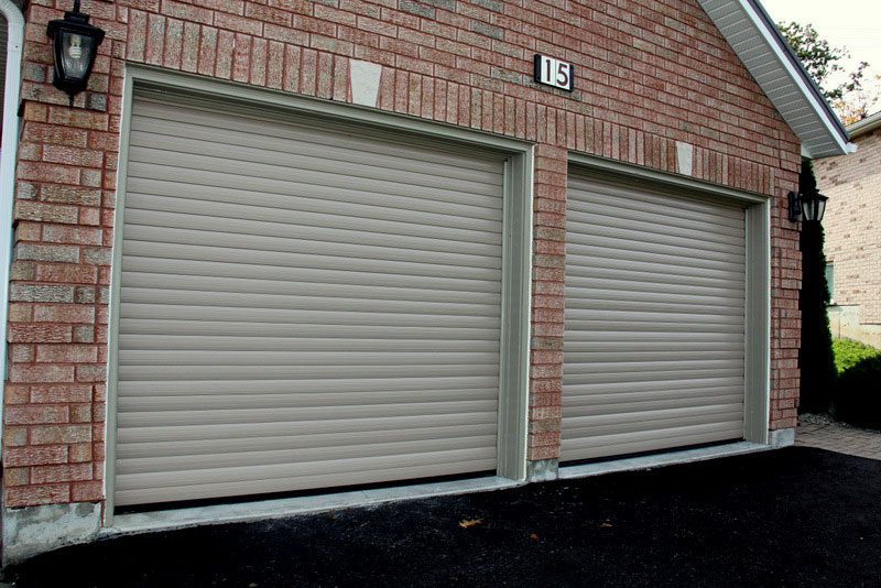 Dual roll-up garage doors on a brick two-car garage