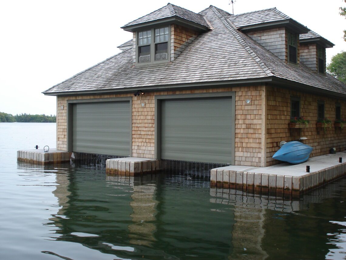 Stone boathouse with a roll-up shutter door at the waterline