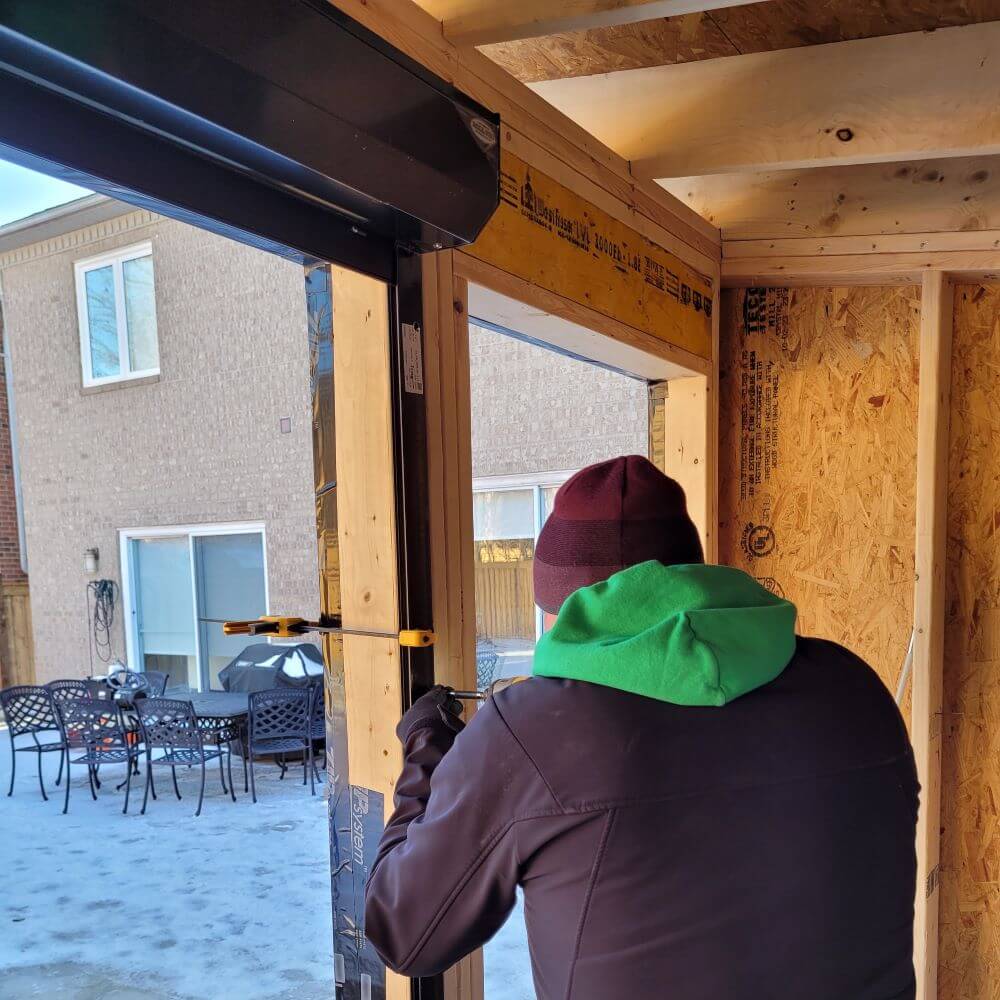 Technician installing a roll-up counter shutter on a pool house patio
