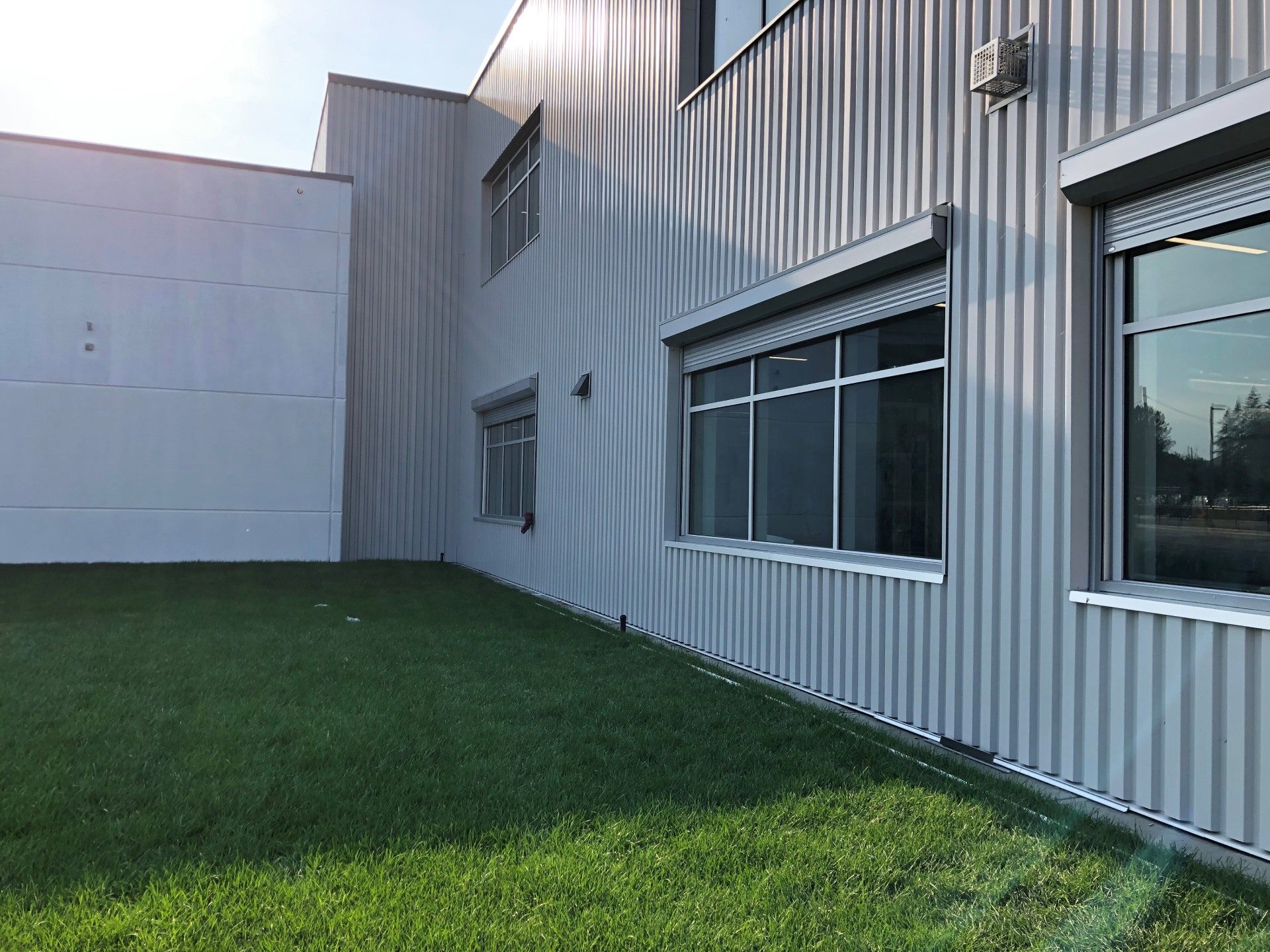 School exterior with roll shutters retracted into slim housings above the classroom windows