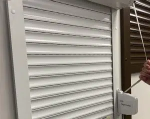 Pull strap and tape winch used to manually operate a roll-up shutter