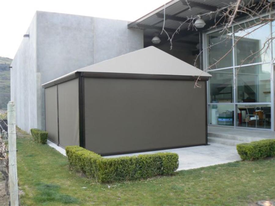 Free-standing outdoor enclosure closed with roll-up screens