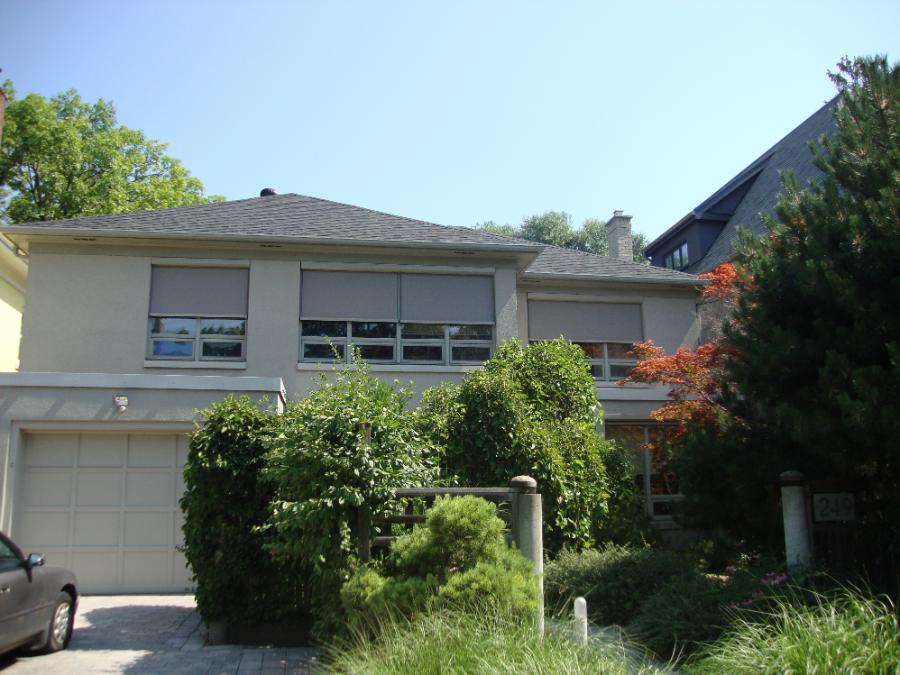 Exterior retractable screens lowered over the windows of a house