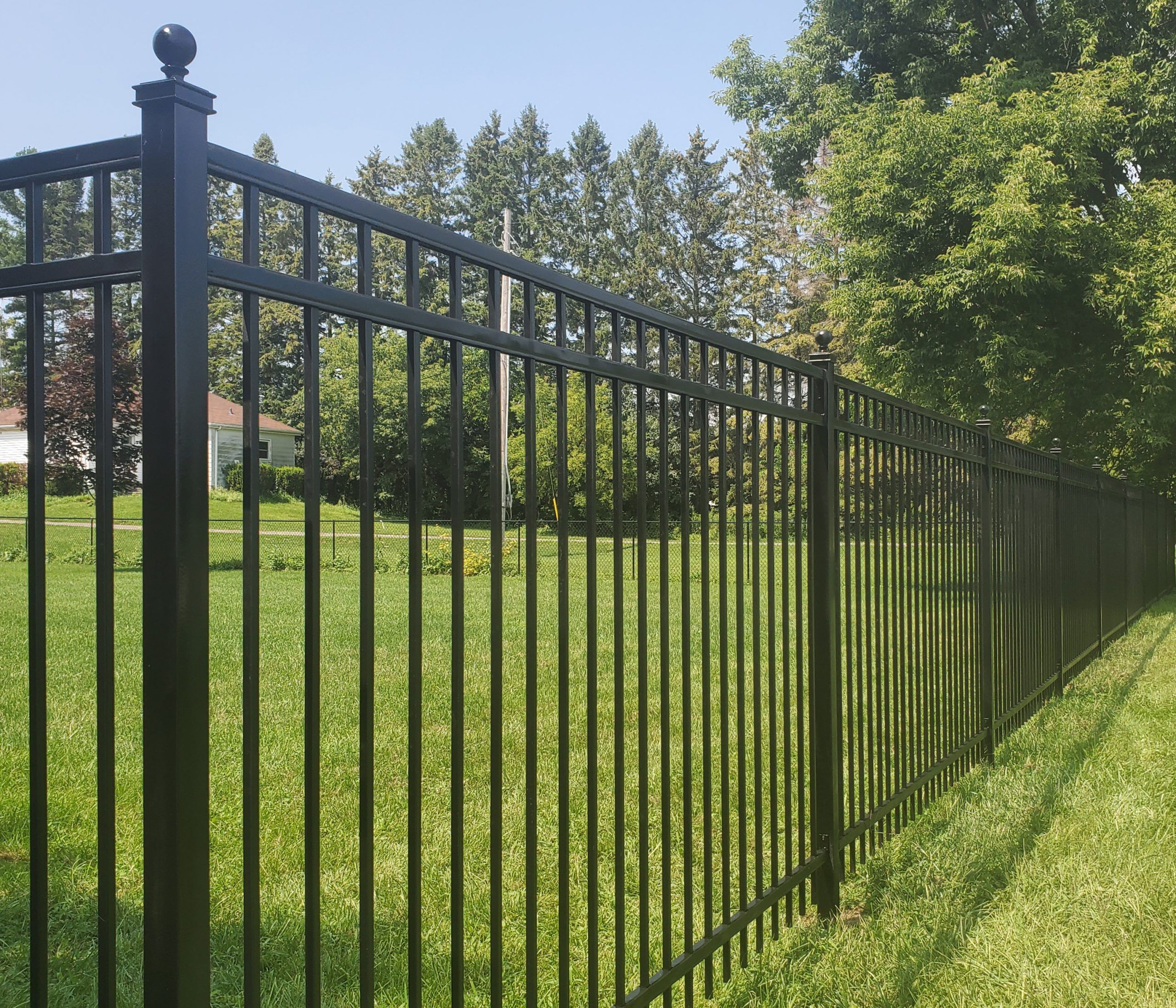 Black metal security fence along a residential property line