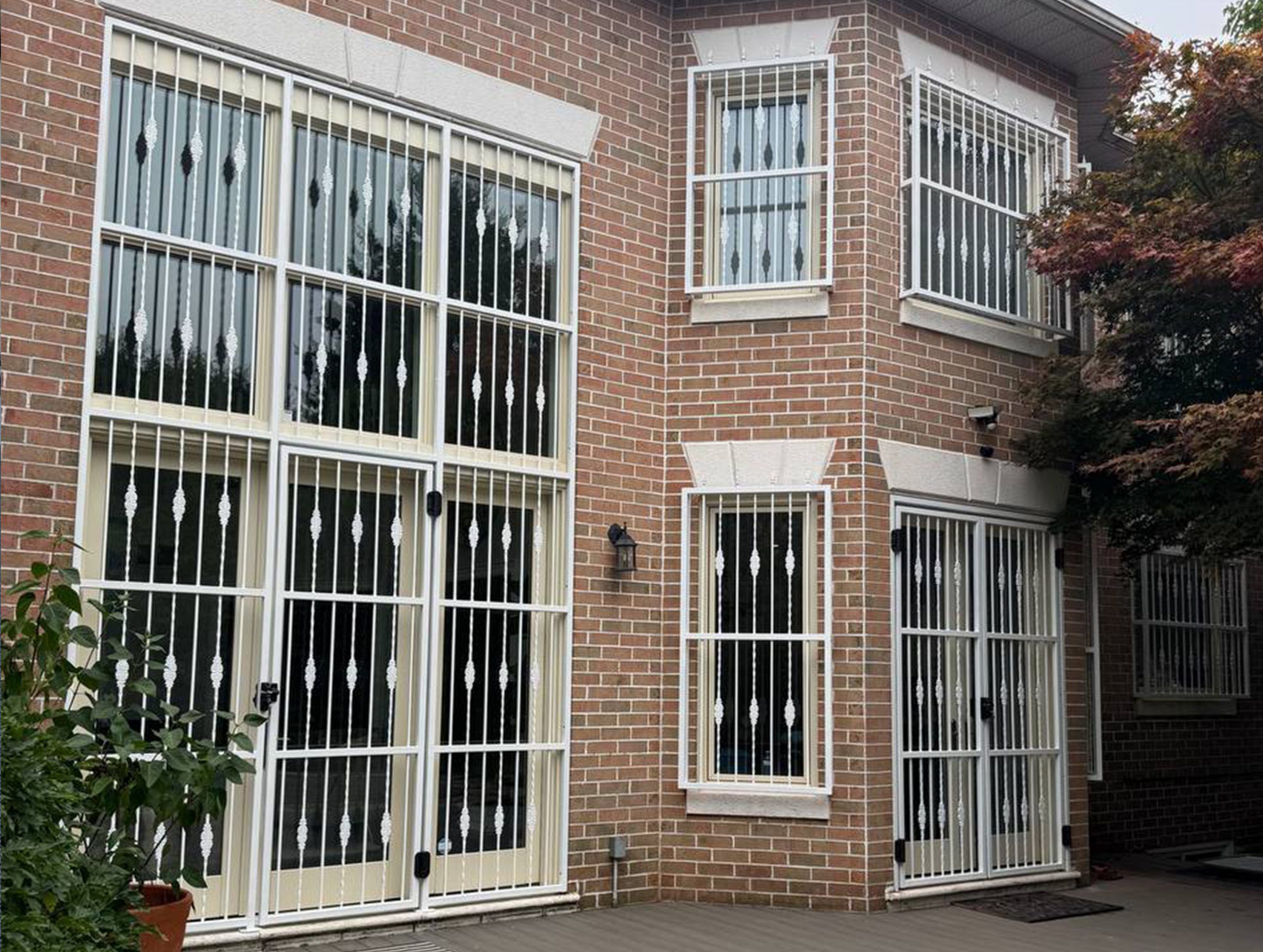 Fixed white security bars installed over residential windows and doors