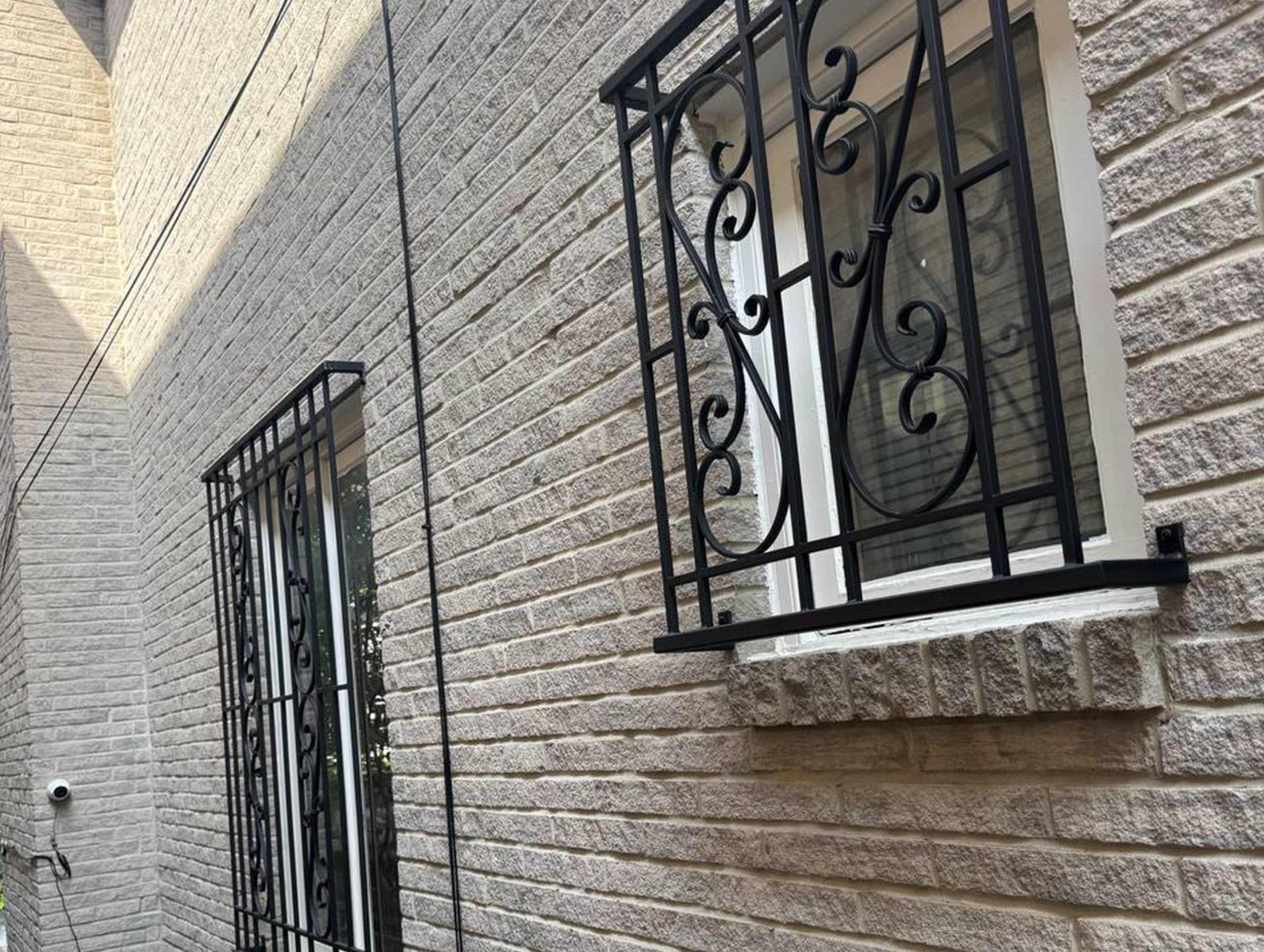 Black metal security bars installed over residential windows and a rear door